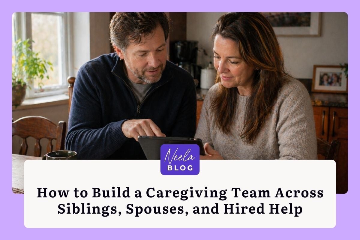 Adult son and daughter sit together at a kitchen table reviewing care information on a tablet, building a caregiving team for their parent.