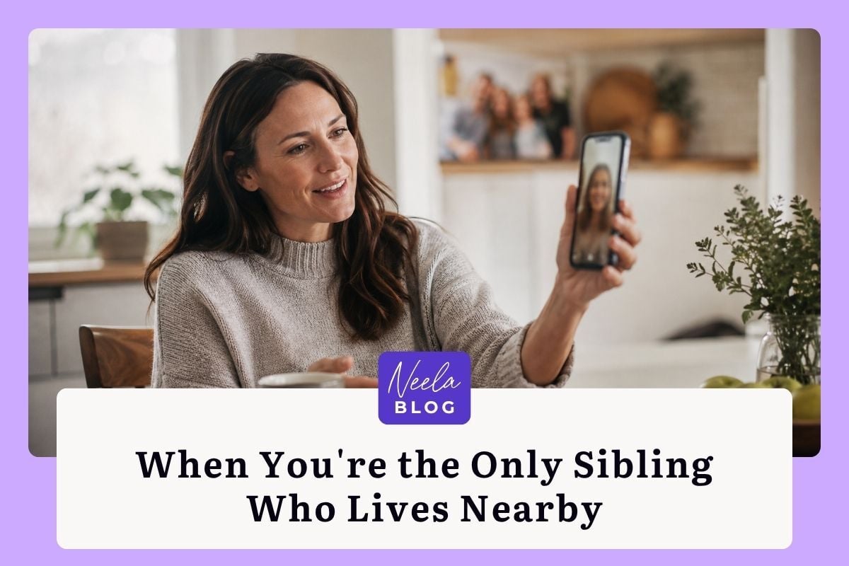 Woman at a kitchen table smiles during a video call with a sibling, sharing family caregiving responsibilities from afar.