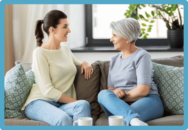 Caregiver discussing symptoms with her older loved one at home, showing how Neela tracks changes and highlights what matters.